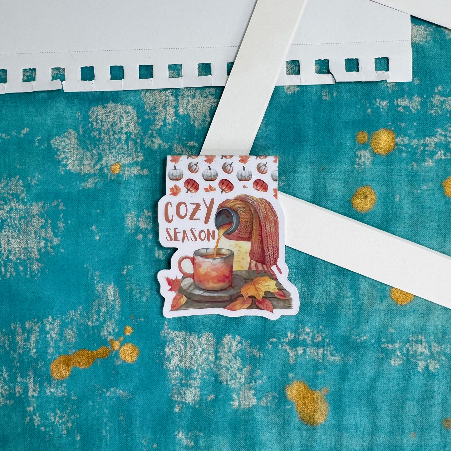 Sticker with 'Cozy Season' design on a textured blue background