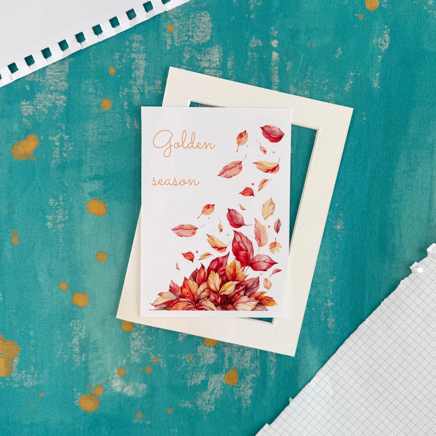 Greeting card with autumn leaves design on a textured teal background