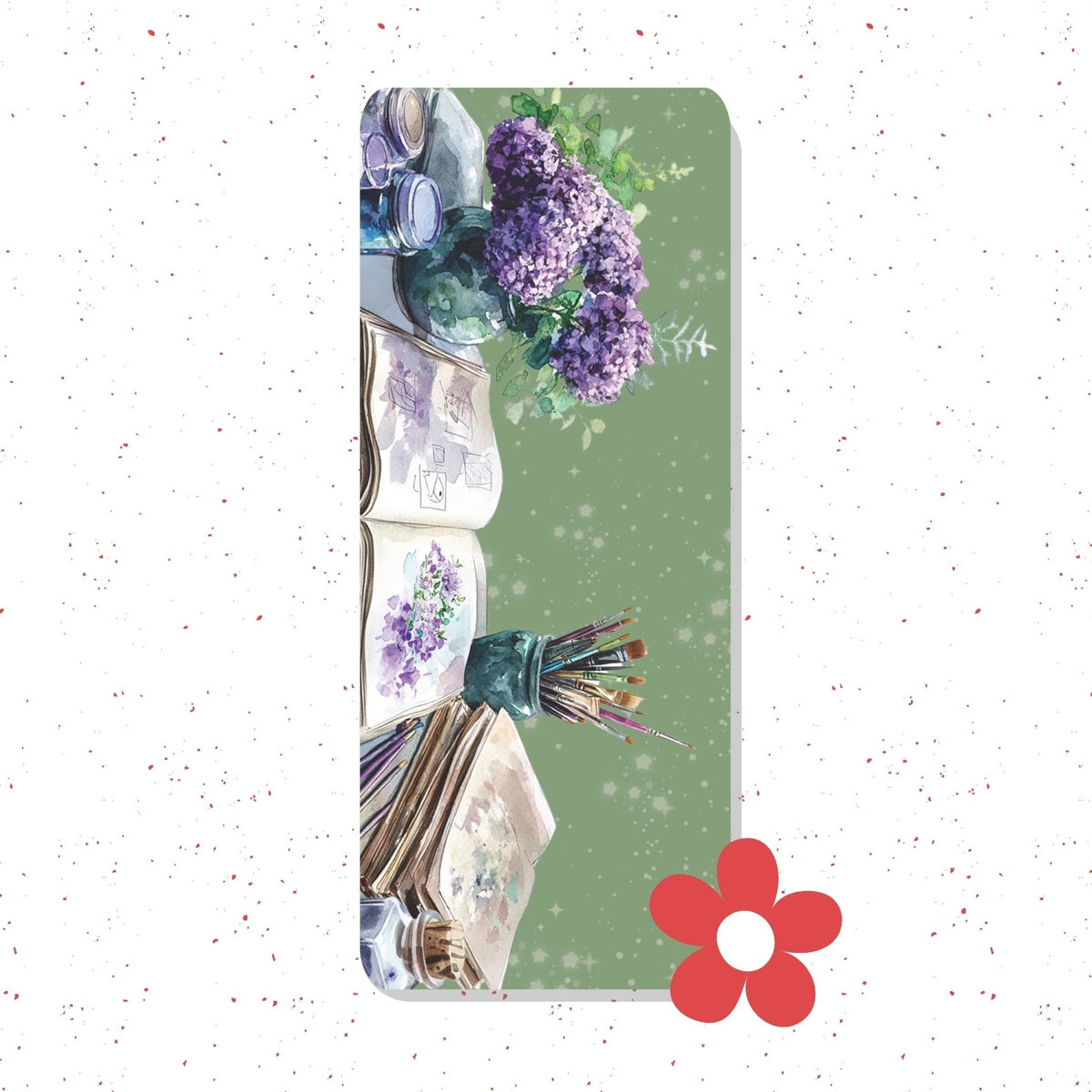A rectangular yoga mat featuring a watercolor-style illustration of purple lilac flowers, open books, and paintbrushes on a sage green background, shown against a white speckled backdrop with a red flower graphic in the lower right.