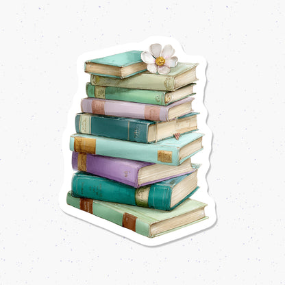 Stack of colorful books with a flower on a light speckled background