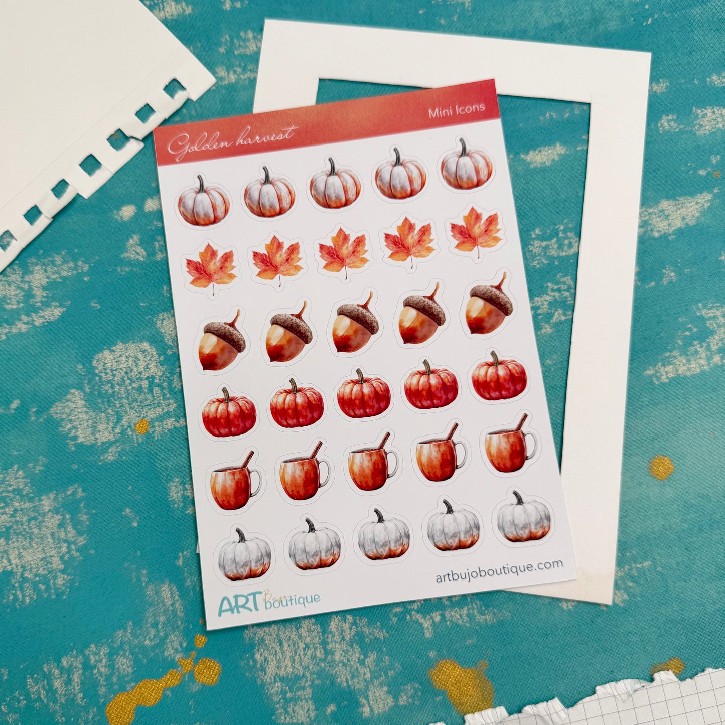Sheet of autumn-themed stickers with pumpkins, leaves, and acorns on a textured blue background.