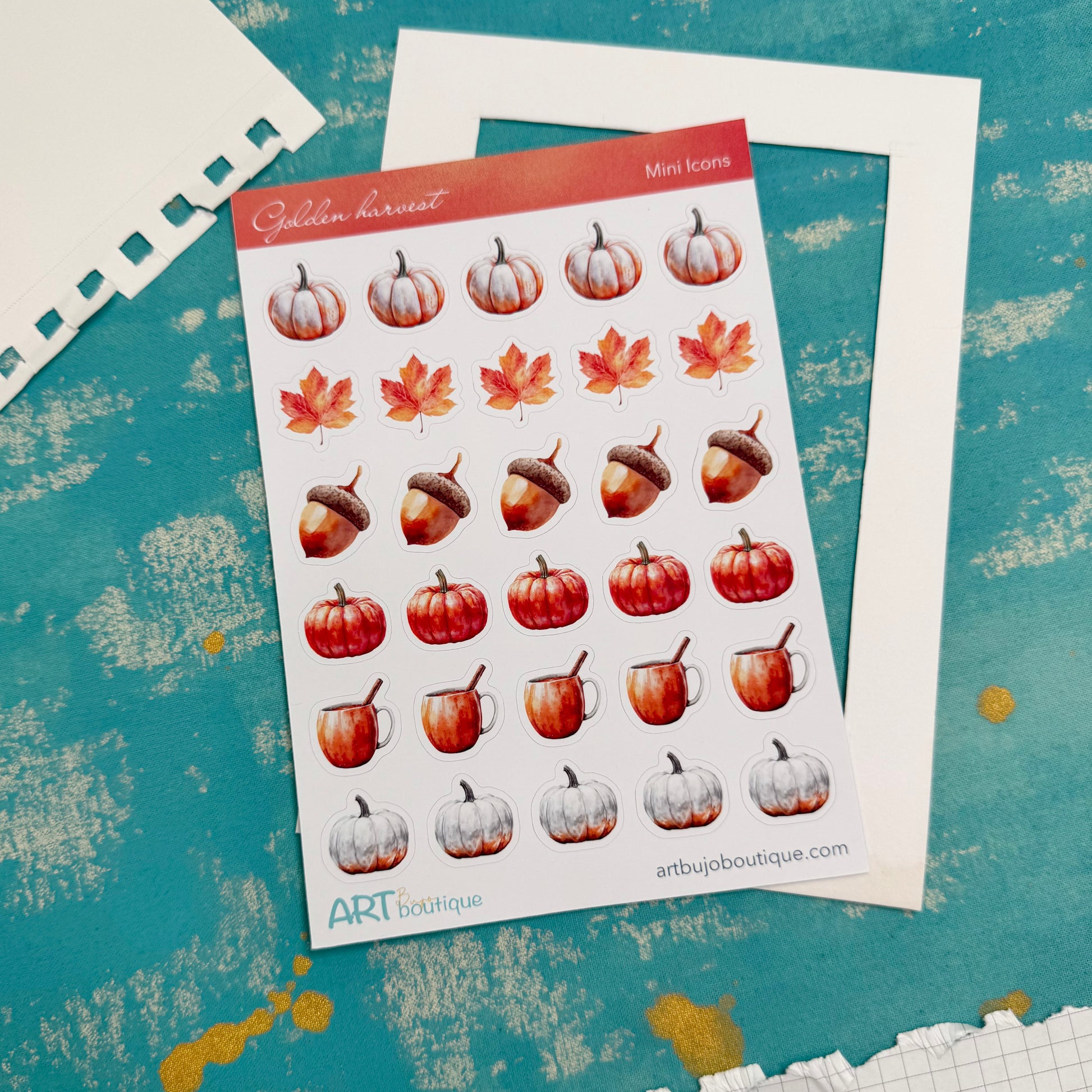 Sheet of autumn-themed stickers with pumpkins, leaves, and acorns on a textured blue background.