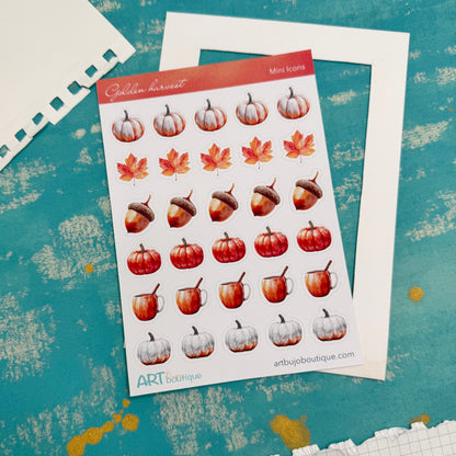Sheet of autumn-themed stickers with pumpkins, leaves, and acorns on a textured blue background.