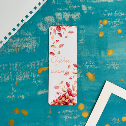 Bookmark with autumn leaves design on a textured blue background