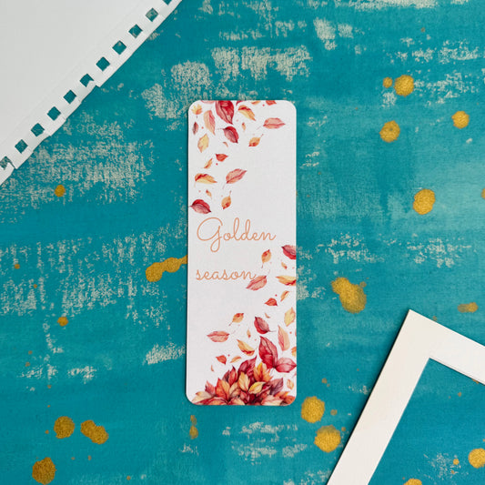 Bookmark with autumn leaves design on a textured blue background
